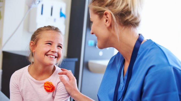 En sykepleier og et smilende barn