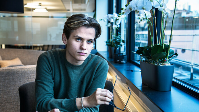 Bilde av Kristoffer Haugen, studentleder, som ser inn i kamera. Han holder briller i hånden.