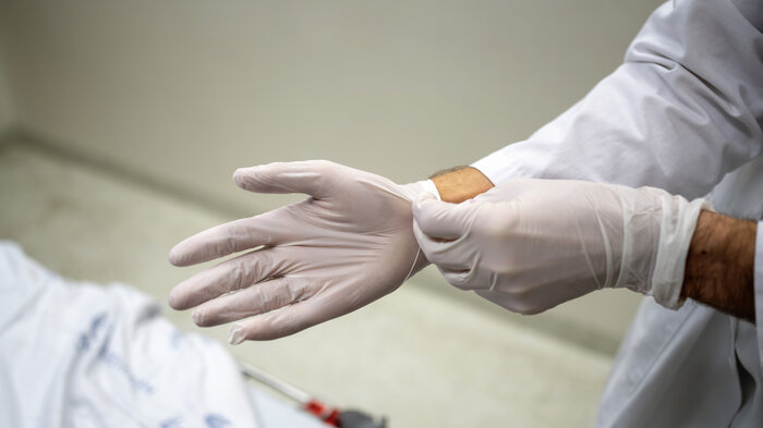 Bilde av helsepersonell som tar på seg hansker