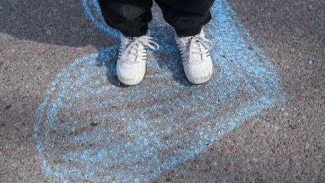 skoleelev og skolehelsjetjeneste Bildet viser et barn som står på et hjertet - tegnet med kritt - i skolegården.