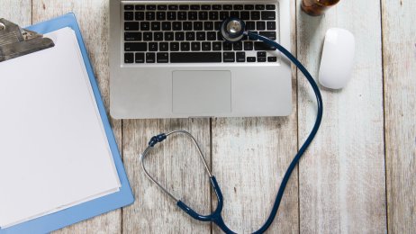 Forskerpult med datamaskin, notatblokk og stetoskop Forskerpult med datamaskin, notatblokk og stetoskop