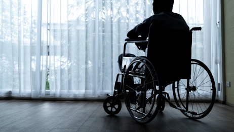 Mann og rullestol Bildet viser en mann som sitter i rullestol.