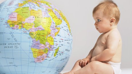 Bilde av en baby som titter på en globus