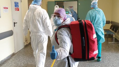 Medisinsk innsatsteam Bildet viser helsepersonell i smittevernutstyr på vei ut av avdeling.