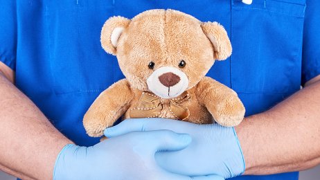 Lege med bamse Bildet viser en lege som holder en bamse