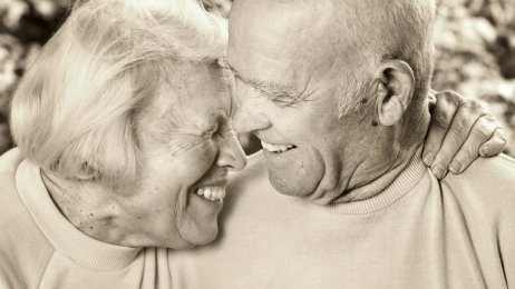 Et eldre par Bildet viser en eldre kvinne som holder rundt en eldre mann. De smiler.