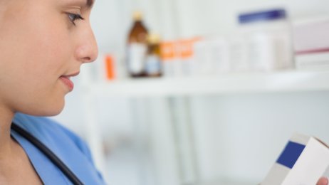 Sykepleier og medikamenter Bildet viser en sykepleier som studerer medikamenter