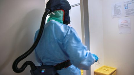 Intensivsykpeleier Bildet viser en intensivsykepleier med smittevernutstyr på jobb