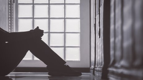 Bildet vise et utsnitt av et menneske som sitter på gulvet