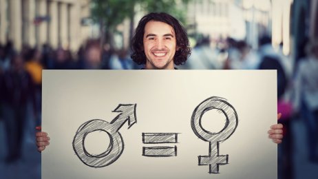 Likestilling Bildet viser en man som holder opp en plakat som viser likhet mellom kjønnene