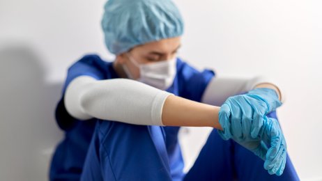 Sliten Bildet viser et slitent helsepersonell med smittevernsutstyr