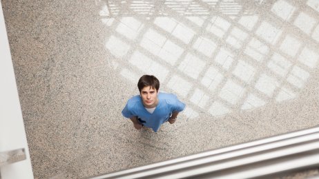 Bildet viser en sykepleier som titter opp mot kamera