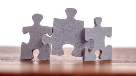 Bildet viser tre puslespillbiter som holder hverandre samlet