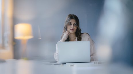 Bildet viser en ung kvinne som jobber på en datamaskin