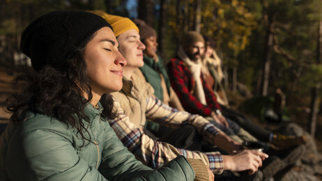 Mennesker som sitter ute og nyter naturen i stillhet. Bildet viser flere mennesker som sitter ute og nyter naturen i stillhet.