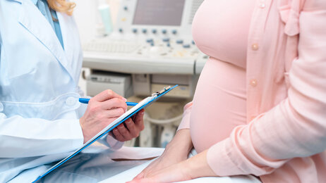Bildet viser et utsnitt av en gravid kvinne hos legen