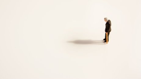 Gammel mann med stokk Bildet viser en skulptur av en gammel mann. Han går med stokk og er helt alene.