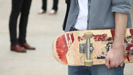 Bilde av en ung mann med skolesekk, og to unge kvinner i bakgrunnen. Bilde av en ung mann med skolesekk, og to unge kvinner i bakgrunnen.