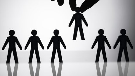 Sykepleiermangel og ufaglærte Bildet viser mange mennesker som står på rekke og rad og en hånd som plukker opp et av menneskene