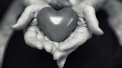 Eldre kvinne med et hjerte i hånden Bildet viser en eldre kvinne som holder et hjerte i hendene.