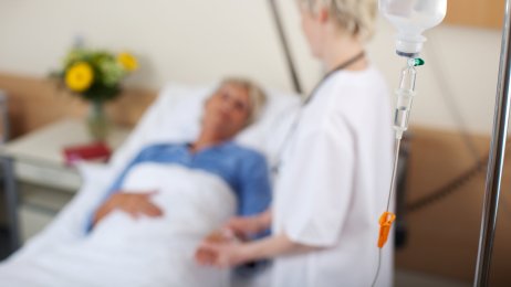 sykepleier står ved sengen til en pasient. sykepleier står ved sengen til en pasient