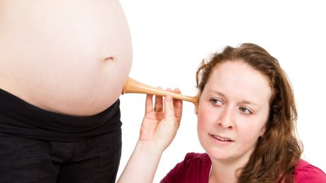 jordmor, svangerskap, svangerskapsomsorg Bildet viser en jordmor som lytter på en mage med jordmorstetoskop.