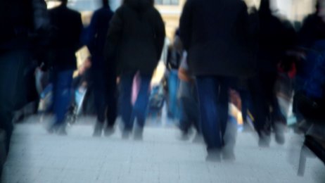 Folkemengde der personene kun ses som svarte, utydelige skikkelser.