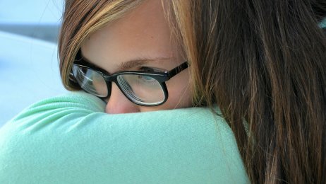 Ung jente Bildet viser en ung jente som gjemmer ansiktet sitt i en pute