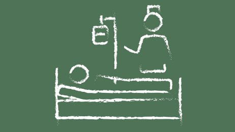 Sykepleier ved pasientseng. Bildet viser en sykepleier som står ved en pasientseng.