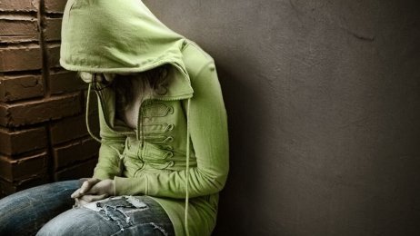 Ungdom depresjon Ung jente, sittende med hettegenser og bøyd rygg