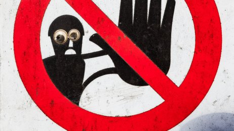 Forbudsskilt Bildet viser et forbudsskilt. En svart skikkelse i bakgrunnen viser stoppsignalet med håndflaten