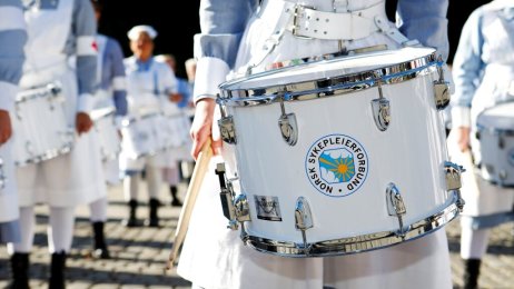 Trommekorpset, NSF Bildet viser en tromme i forgrunnen og NSFs trommekorps i bakgrunnen.