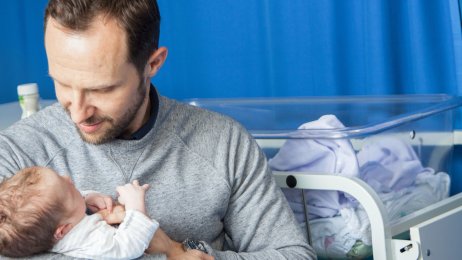 Nyfødt Bildet viser en nybakt far som holder en nyfødt baby