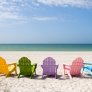 bildet viser tomme solstoler på en strand