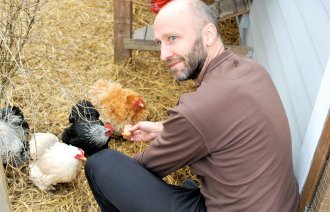Bildet er et portrett av doktorand Knut Ove Æsøy som mater hønene sine.