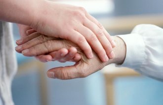 Bildet viser to hender som holder hverandre