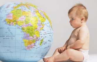 Bilde av en baby som titter på en globus