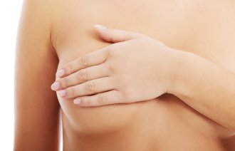 Bildet viser en naken kvinne som holder hånden over det ene brystet.