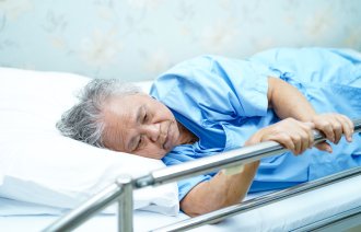 Bildet viser asiatisk pasient i sykehusseng