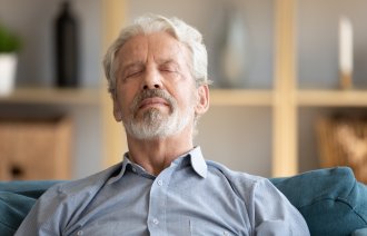 Eldre mann hviler med lukkede øyne.