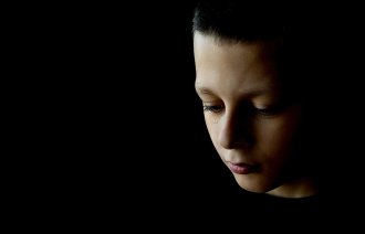 Bildet viser en trist gutt.