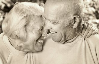 Et eldre par Bildet viser en eldre kvinne som holder rundt en eldre mann. De smiler.