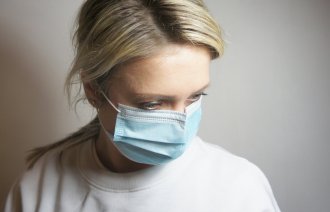 Bildet viser en kvinne med munnbind