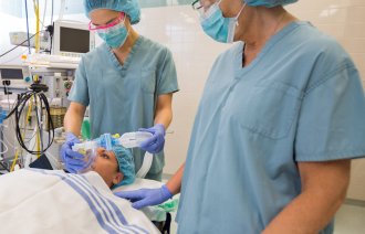 Pasient klargjøres til operasjon Bildet viser sykepleiere som forbereder en pasient for operasjon