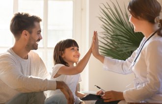 En jente og faren er hos en sykepleier på legevakten