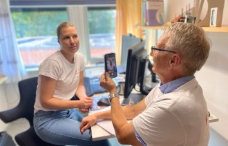 Bildet viser Jørn Hustad som tar bilde av Marianne Sjuls med mobiltelefon.