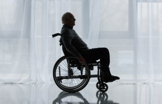 Bildet viser en eldre mann som sitter i rullestol