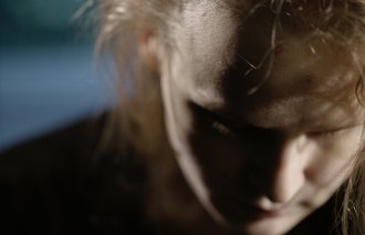 Bildet viser en kvinne med bøyd hode.