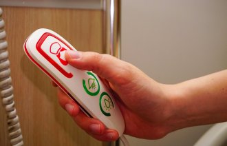 Bildet viser en pasient som tilkaller helsepersonell fra sykesengen. 