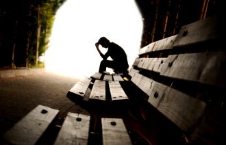 En deprimert mann på en benk. 